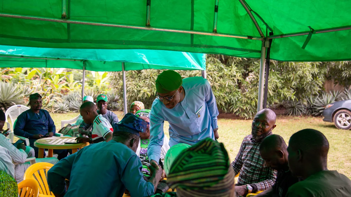 Ayobami greeting supporters at a community meeting